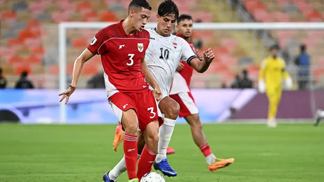 Pemain Timnas Irak, Mohandad Ali (tengah), mengoper bola saat pemain Timnas Indonesia, Jay Idzes, mengejar dalam pertandingan kualifikasi Grup B Piala Dunia antara Irak dan Indonesia di Stadion Alinma Bank, King Abdullah Sports City, Jeddah, Arab Saudi, Minggu (12-10-2025) dini hari WIB. (Foto AP/Ali Issa)
