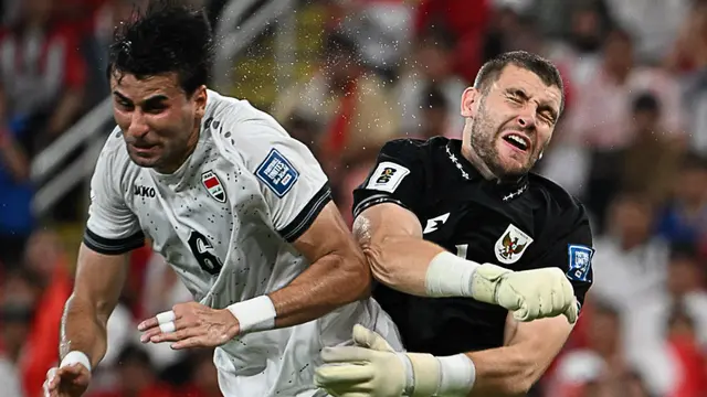 Kiper Timnas Indonesia, Maarten Paes (kanan), berduel dengan pemain Timnas Irak, Munaf Younus (kiri), dalam pertandingan kualifikasi Grup B Piala Dunia antara Irak dan Indonesia di Stadion Alinma Bank, King Abdullah Sports City, Jeddah, Arab Saudi, Minggu (12-10-2025) dini hari WIB. (Foto AP/Ali Issa)