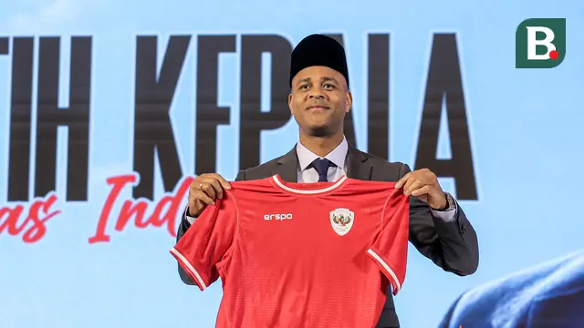 Pelatih kepala baru Timnas Indonesia, Patrick Kluivert berpose dengan memegang jersey dan memakai peci setelah sesi konferensi pers yang berlangsung di Hotel Mulia, Senayan, Jakarta, Minggu (12/01/2025). (Bola.com/Bagaskara Lazuardi)