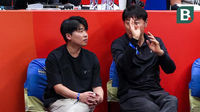 Pelatih Timnas Indonesia, Shin Tae-yong (kanan), berbincang dengan penerjemahnya, Jeong Seok-seo, saat menonton laga Grup H Piala Dunia FIBA 2023 antara Kanada melawan Latvia di Indonesia Arena, Senayan, Jakarta, Selasa (29/08/2023). (Bola.com/Bagaskara Lazuardi)