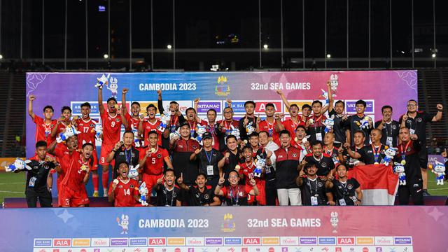 Ketua Umum PSSI Erick Thohir (tengah), Menpora Dito Ariotedjo, Ketua NOC Indonesia Raja Sapta Oktohari, CdM Lexyndo Hakim, staf pelatih, ofisial, dan pemain Timnas Indonesia U-22 berpose memegang medali emas SEA Games 2023 setelah mengalahkan Thailand dengan skor 5-2 pada laga final yang berlangsung di Olympic Stadium, Phnom Penh, Kamboja, Selasa (16/05/2023). (AFP/Nhac Nguyen)