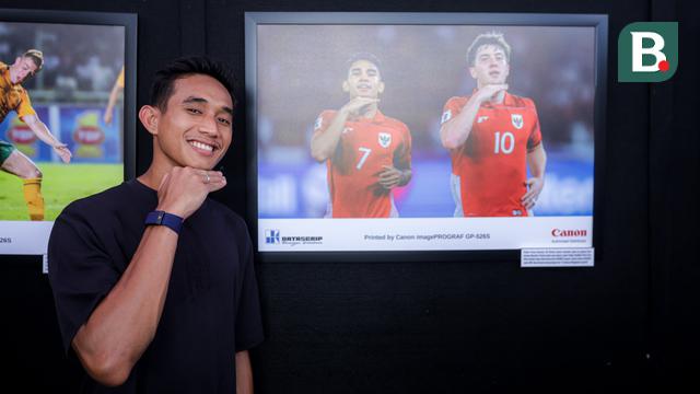 Pemain Timnas Indonesia, Rizky Ridho berpose di samping foto karya pewarta foto  Bagaskara Lazuardi dalam pameran foto Media Cup 2025 yang bertema 