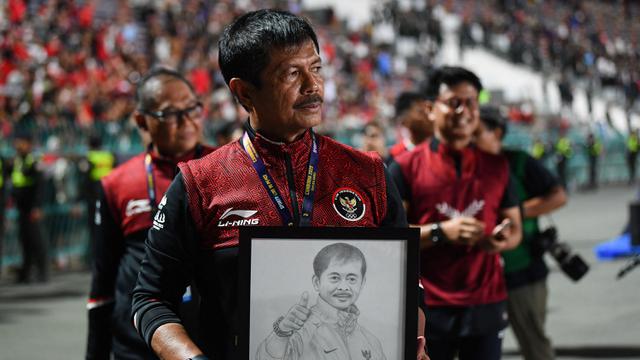 Pelatih kepala Timnas Indonesia U-22, Indra Sjafri memegang gambar dirinya saat merayakan kemenangan pada laga final sepak bola SEA Games 2023 melawan Thailand di Olympic Stadium, Phnom Penh, Kamboja, Selasa (16/05/2023). Skuad Garuda Nusantara menang dengan skor 5-2. (AFP/Nhac Ngyuen)