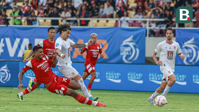 Penyerang asing Malut United, Diego Maximo Martinez, sedang berusaha untuk melindungi bola dari rebutan bek asing Persis Solo, Cleylton Santos, dalam duel di Stadion Manahan, Solo, Sabtu (12/4/2025). (Bola.com/Radifa Arsa)