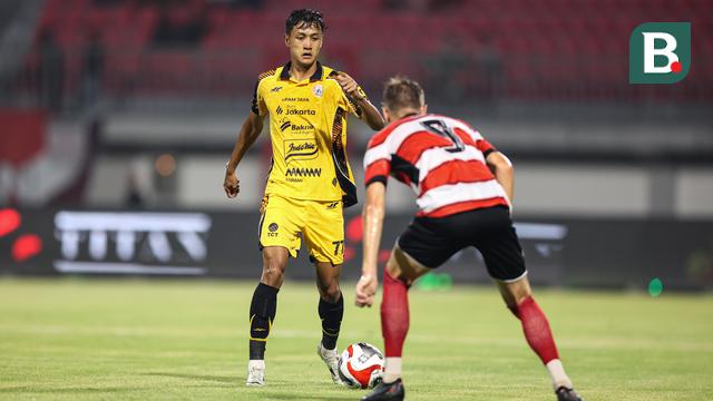 Pemain Persija Jakarta, Dony Tri Pamungkas (kiri) mencoba melewati pemain Madura United pada lanjutan BRI Super League 2025/2026 di Stadion Gelora Ratu Pamelingan, Jumat (24/10/2025) malam WIB. (Bola.com/Abdul Aziz).