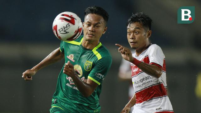 Gelandang Persebaya Surabaya, Koko Ari (kiri) berebut bola dengan striker Madura United, Mochammad Kevy dalam laga matchday ke-2 Grup C Piala Menpora 2021 di Stadion Si Jalak Harupat, Bandung, Minggu (28/3/2021). (Bola.com/M Iqbal Ichsan)