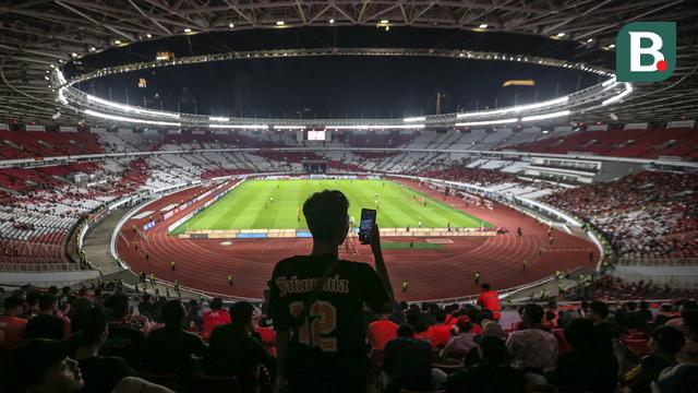 Seorang pendukung Persija Jakarta mengabadikan momen menggunakan gawainya sebelum laga terakhir BRI Liga 1 2022/2023 antara Persija Jakarta melawan PSS Sleman di Stadion Utama Gelora Bung Karno (SUGBK), Senayan, Jakarta, Sabtu (15/04/2023). (Bola.com/Bagaskara Lazuardi)
