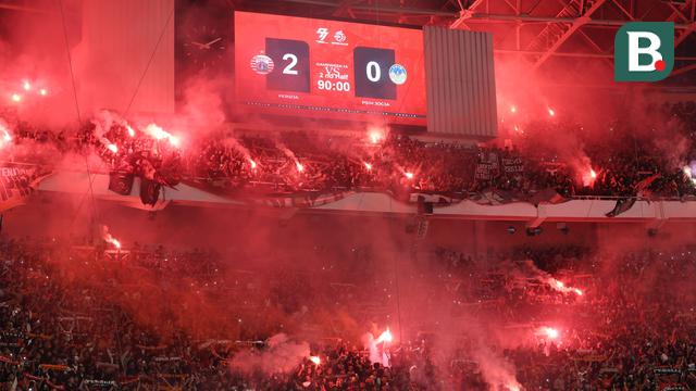 The Jakmania menyalakan Flare saat merayakan kemenangan Persija Jakarta atas PSIM Yogyakarta pada laga pekan ke-14 BRI Super League 2025/2026 di Stadion Utama Gelora Bung Karno, Jakarta, Jumat (28/11/2025) malam. (Bola.com/M Iqbal Ichsan)