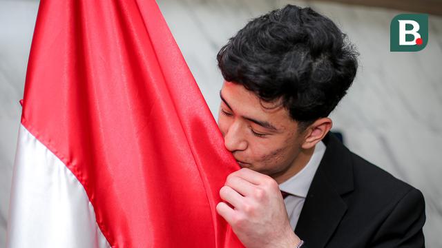 Kiper keturunan Indonesia-Iran, Cyrus Margono mencium bendera Merah Putih setelah mengambil sumpah Warga Negara Indonesia (WNI) di Kanwil Kemenkumham DKI, Cawang, Jakarta, Kamis (21/03/2024). (Bola.com/Bagaskara Lazuardi)