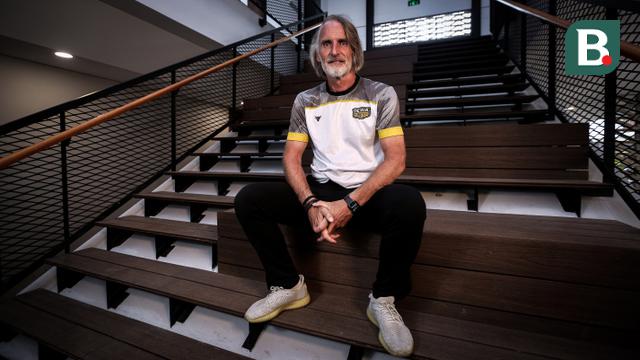 Pelatih Dewa United, Jan Olde Riekerink berpose di depan fotografer setelah melakukan sesi wawancara di basecamp Dewa United, Pagedangan, Tangerang, Selasa (18/07/2023). (Bola.com/Bagaskara Lazuardi)