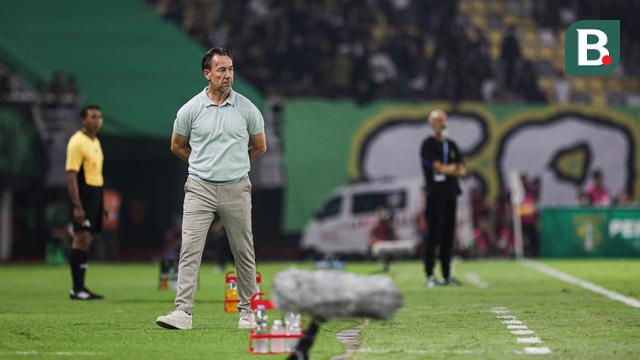 Pelatih PSIM Yogyakarta, Jean-Paul Van Gastel saat memberikan instruksi di pinggir lapangan ketika melawan Persebaya Surabaya pada BRI Super League 2025/2026 di Stadion Gelora Bung Tomo, Surabaya, Jumat (8/8/2025). (Bola.com/Abdul Aziz) 