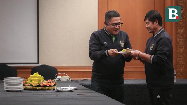 Anggota Exco PSSI yang sekaligus menjabat manajer tim, Endri Irawan memberikan potongan tumpeng kepada pelatih kepala Timnas Indonesia U-22, Indra Sjafri saat syukuran terkait sanksi ringan FIFA terhadap Indonesia dan kesempatan Timnas Indonesia U-22 tampil di SEA Games 2023 di Ruang Semeru, Hotel Sultan, Jakarta. (Bola.com/Bagaskara Lazuardi)